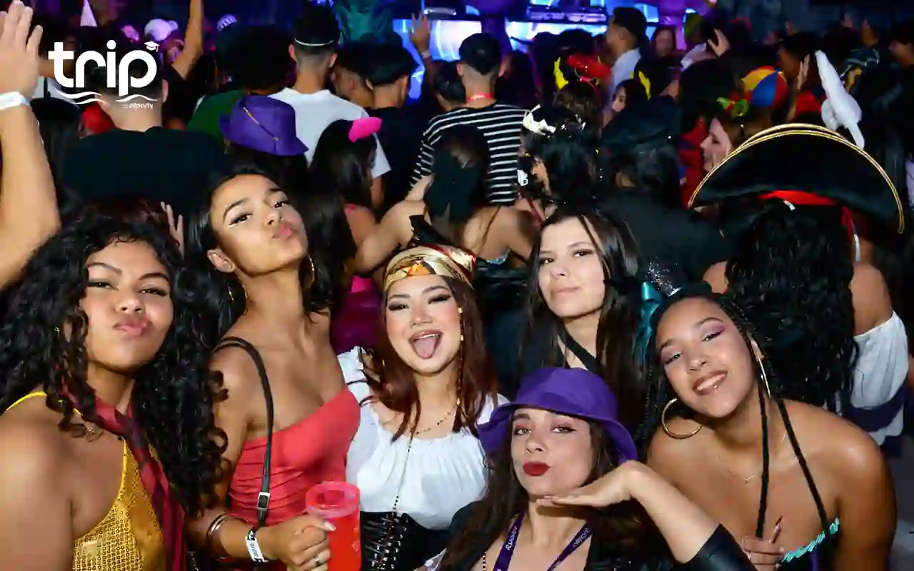 Grupo de formandos fantasiados dançando com o DJ ao fundo