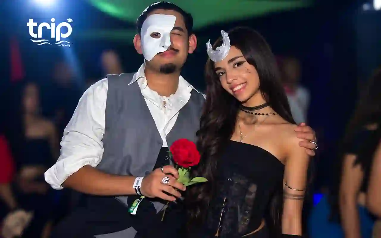 Casal fantasiado na Festa à Fantasia, ele de máscara e ela com uma rosa